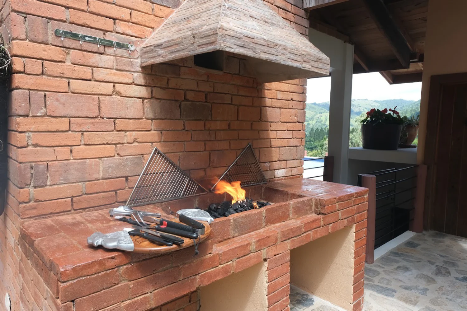 The brick grill lit and ready, mountains beyond