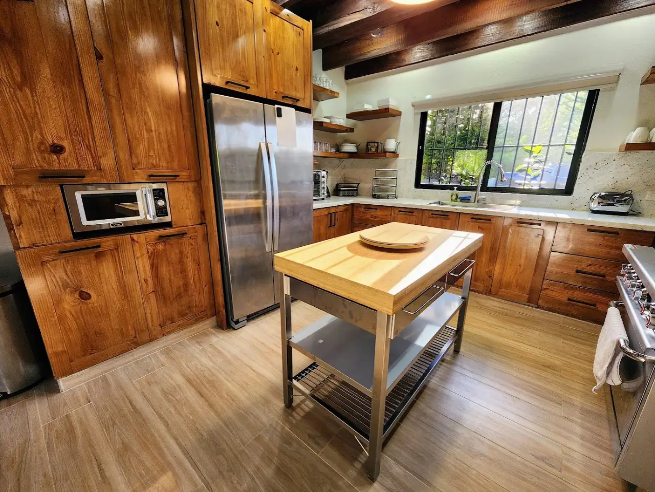 The butcher-block island, gas range and garden window