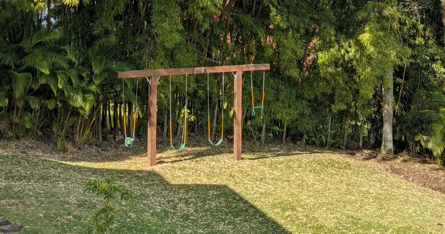 The swing set on the lawn, framed by bamboo