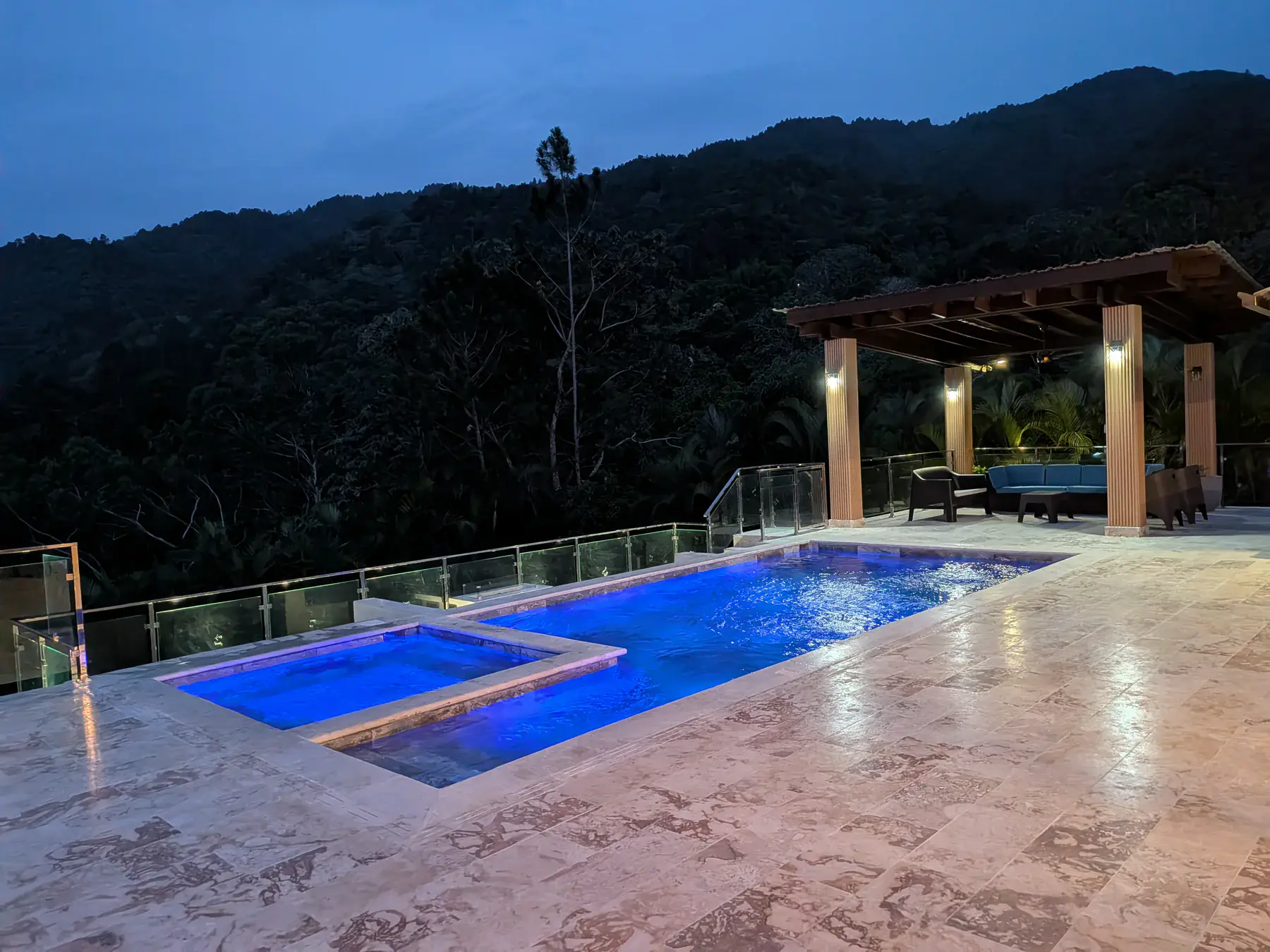 The pool, jacuzzi and lounge at dusk